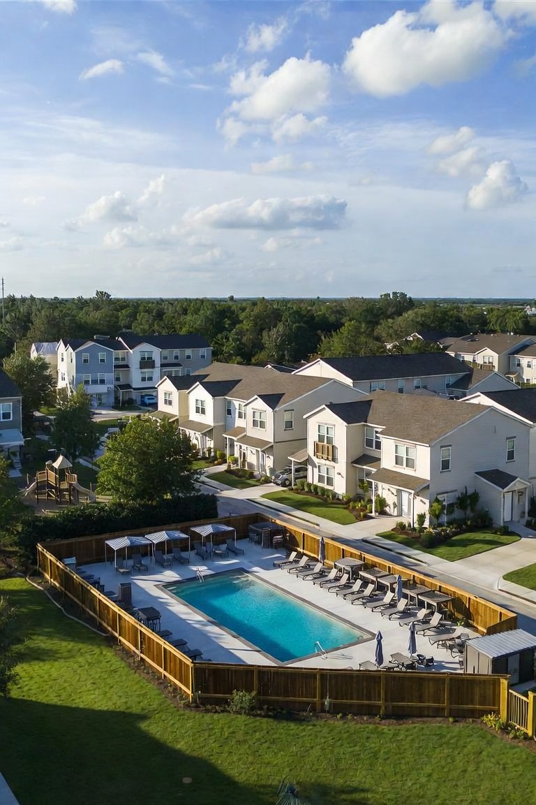 Aerial view of a residential community with pool and green space